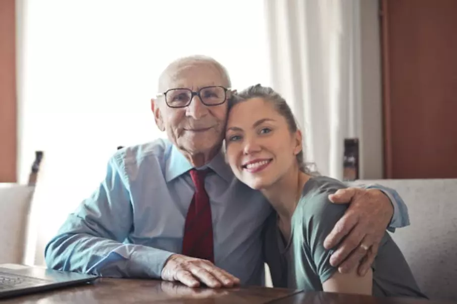 Senior person hugging a younger person 